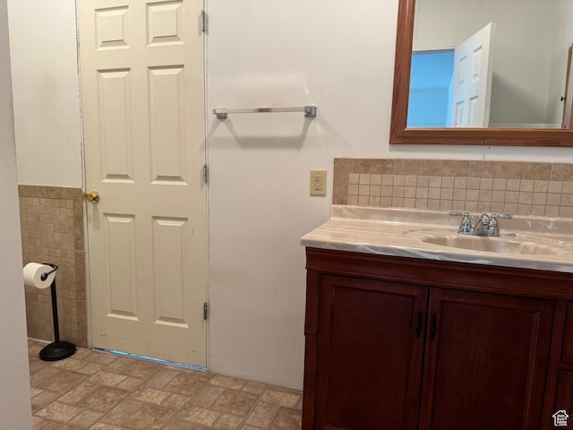 bathroom featuring vanity and tile walls