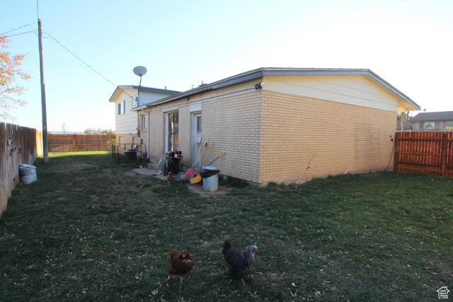 10 N 700 E, Roosevelt, UT 84066 - view of property exterior with a lawn, a fenced backyard, and brick siding