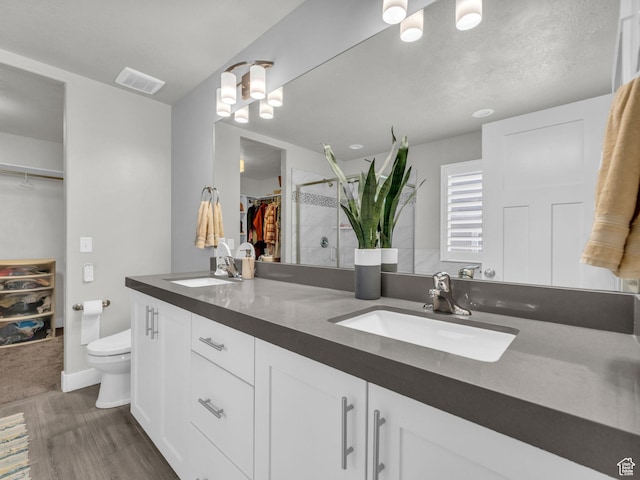 13952 S Indian Ln E, Herriman, UT 84096 - bathroom with wood finished floors, toilet, double vanity, a tile shower, and a spacious closet
