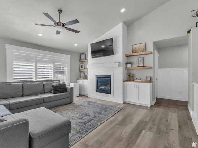 13952 S Indian Ln E, Herriman, UT 84096 - living area featuring lofted ceiling, a ceiling fan, a fireplace, light wood-style floors, and a wainscoted wall
