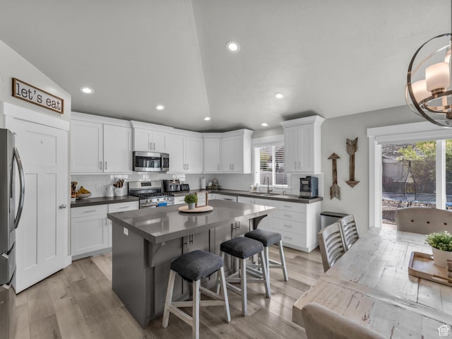 13952 S Indian Ln E, Herriman, UT 84096 - kitchen with stainless steel appliances, a sink, dark countertops, light wood-style flooring, and recessed lighting