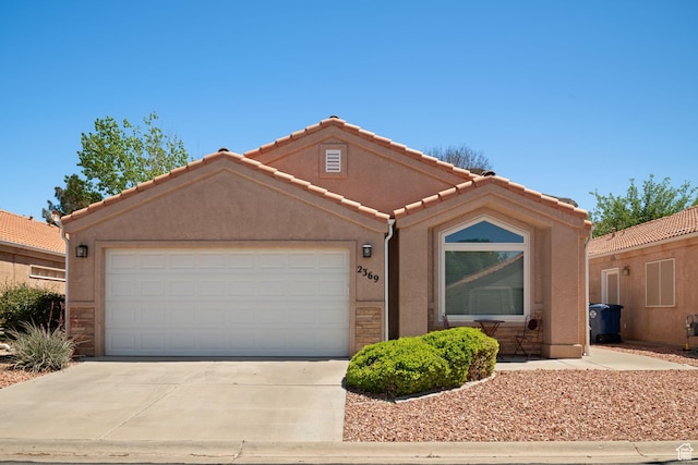 ranch-style house with concrete driveway, stone siding, a tiled roof, stucco siding, and a garage