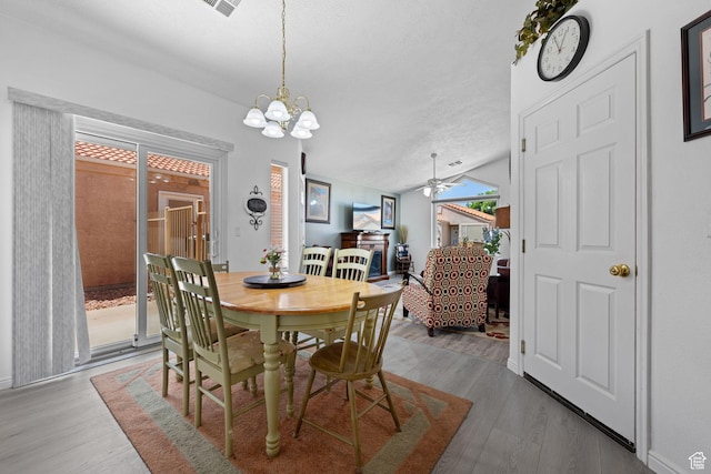 2369 S 780 W, Hurricane, UT 84737 - dining space featuring a textured ceiling, wood finished floors, vaulted ceiling, and ceiling fan with notable chandelier