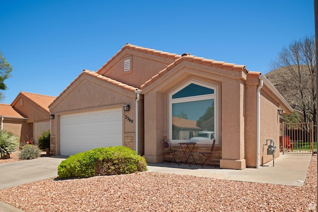 2369 S 780 W, Hurricane, UT 84737 - ranch-style house with fence, concrete driveway, a tiled roof, stucco siding, and a garage