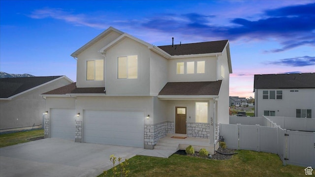 574 W 500 N, Smithfield, UT 84335 - traditional-style house with stucco siding, fence, driveway, stone siding, and an attached garage