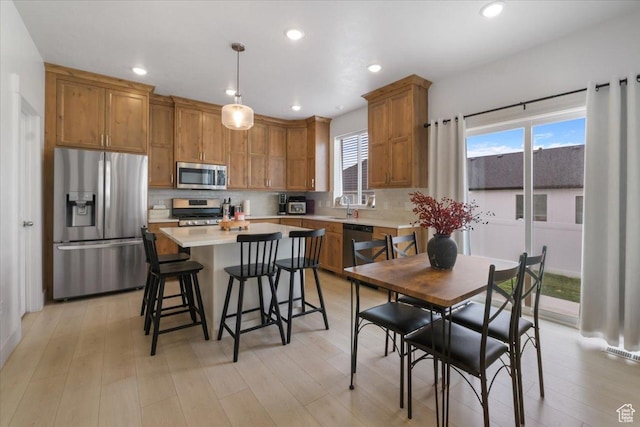 574 W 500 N, Smithfield, UT 84335 - kitchen featuring decorative backsplash, appliances with stainless steel finishes, brown cabinetry, and light countertops