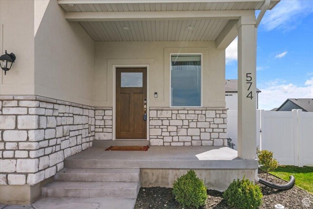 574 W 500 N, Smithfield, UT 84335 - view of exterior entry featuring fence, stucco siding, and stone siding