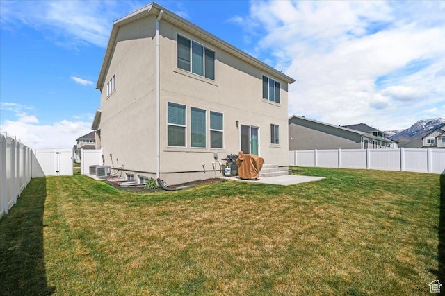 574 W 500 N, Smithfield, UT 84335 - rear view of house with a lawn, a fenced backyard, stucco siding, and central air condition unit