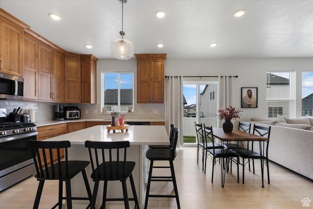574 W 500 N, Smithfield, UT 84335 - kitchen featuring a kitchen breakfast bar, stainless steel appliances, plenty of natural light, and light countertops