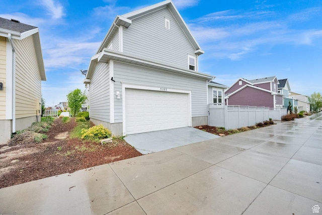 5103 W S Jordan Pkwy, South Jordan, UT 84009 - view of side of property with fence, concrete driveway, a residential view, and a garage