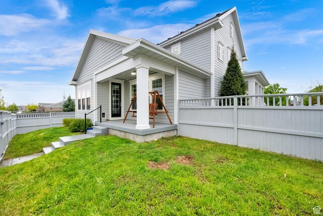 5103 W S Jordan Pkwy, South Jordan, UT 84009 - view of front facade featuring covered porch, a front yard, and a fenced backyard