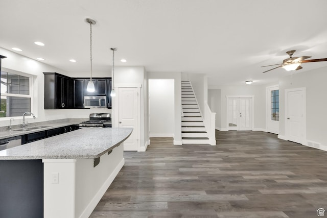 5103 W S Jordan Pkwy, South Jordan, UT 84009 - kitchen featuring light stone counters, appliances with stainless steel finishes, a sink, a center island, and open floor plan