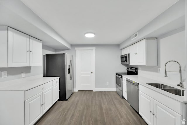 5103 W S Jordan Pkwy, South Jordan, UT 84009 - kitchen featuring a sink, stainless steel appliances, light wood-type flooring, visible vents, and white cabinets