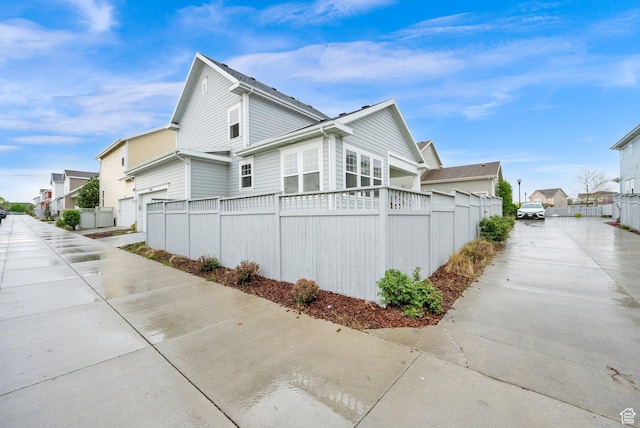 5103 W S Jordan Pkwy, South Jordan, UT 84009 - view of side of property featuring fence, concrete driveway, a residential view, and a garage