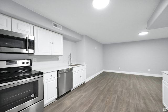 5103 W S Jordan Pkwy, South Jordan, UT 84009 - kitchen with a sink, stainless steel appliances, baseboards, white cabinets, and wood finished floors