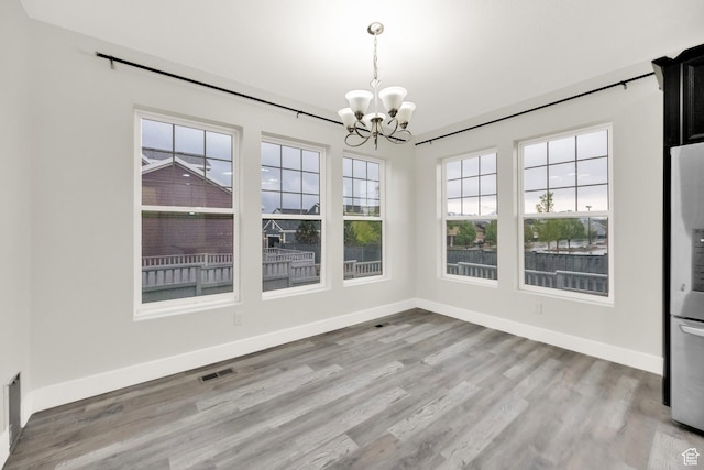 5103 W S Jordan Pkwy, South Jordan, UT 84009 - unfurnished dining area with wood finished floors, a chandelier, visible vents, and baseboards