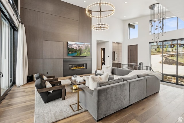 4014 Aspen Camp Loop, Park City, UT 84098 - living room featuring recessed lighting, a high ceiling, light wood-style floors, a notable chandelier, and a glass covered fireplace