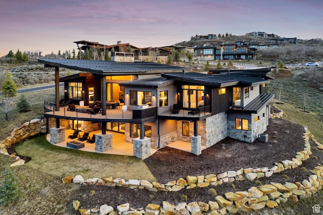 4014 Aspen Camp Loop, Park City, UT 84098 - rear view of property featuring metal roof, stone siding, a balcony, and a patio area