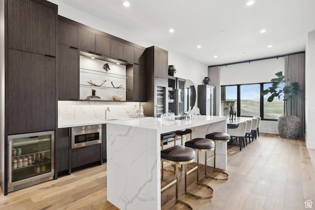 4014 Aspen Camp Loop, Park City, UT 84098 - kitchen featuring recessed lighting, dark brown cabinetry, a breakfast bar, a sink, and wine cooler