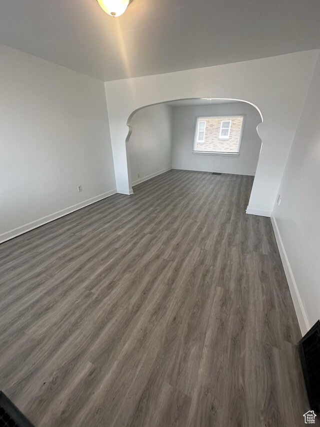 983 29th St, Ogden, UT 84403 - empty room featuring arched walkways and dark wood-style floors