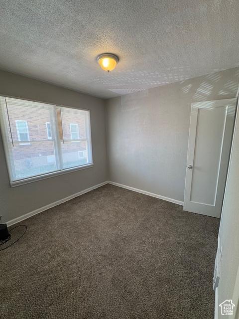 983 29th St, Ogden, UT 84403 - spare room featuring dark carpet and a textured ceiling