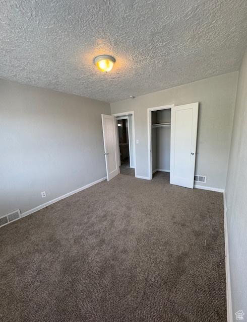983 29th St, Ogden, UT 84403 - unfurnished bedroom with carpet, a textured ceiling, and a closet