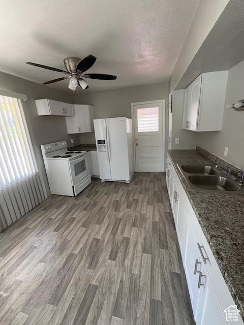 983 29th St, Ogden, UT 84403 - kitchen with white appliances, white cabinets, a ceiling fan, wood finished floors, and a textured ceiling