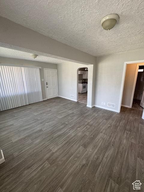 983 29th St, Ogden, UT 84403 - unfurnished room with dark wood finished floors, arched walkways, and a textured ceiling