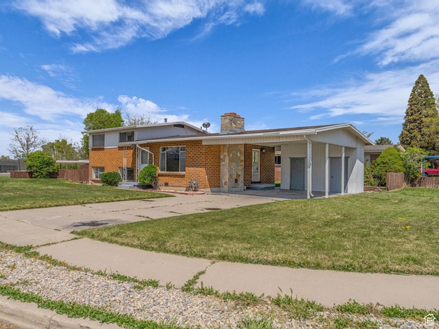 8323 S Adams St, Midvale, UT 84047 - view of front of house featuring brick siding, a carport, a chimney, and driveway