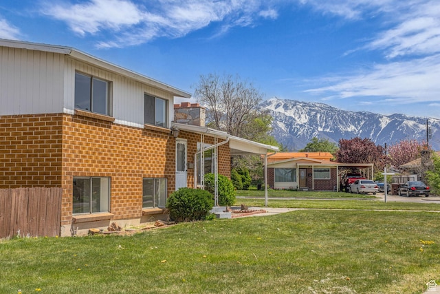 8323 S Adams St, Midvale, UT 84047 - back of property featuring brick siding, a mountain view, and a lawn