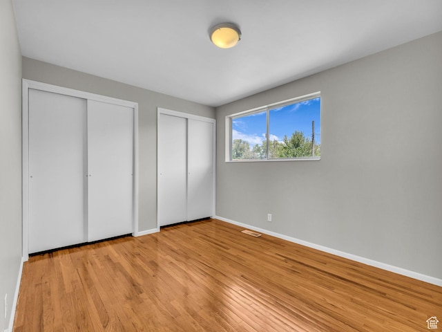 8323 S Adams St, Midvale, UT 84047 - unfurnished bedroom featuring two closets, light wood-style flooring, and baseboards