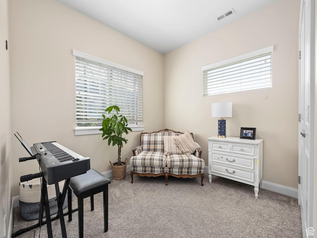 sitting room with visible vents, carpet flooring, a wealth of natural light, and baseboards