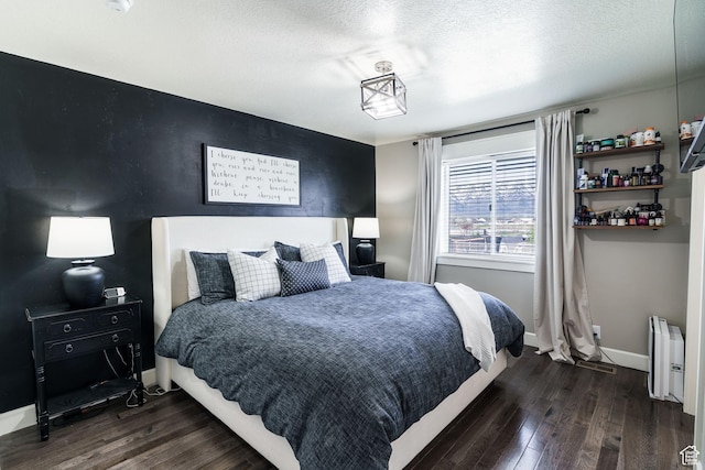 2783 S 1100 W, Nibley, UT 84321 - bedroom featuring baseboards, radiator heating unit, a textured ceiling, and dark wood-type flooring