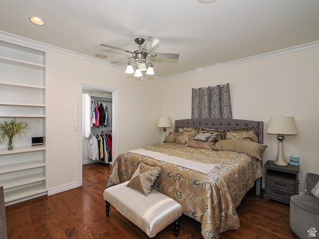 bedroom with a spacious closet, ornamental molding, wood finished floors, and a closet