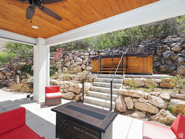 view of patio / terrace with ceiling fan and a hot tub