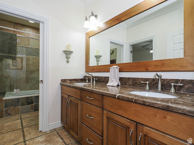 bathroom featuring tiled shower / bath, double vanity, a sink, and baseboards