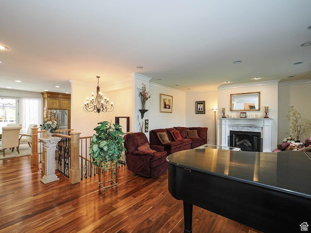 living room featuring recessed lighting, dark wood-style flooring, a chandelier, a fireplace, and ornamental molding