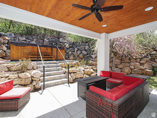 view of patio / terrace featuring an outdoor living space, ceiling fan, and a hot tub