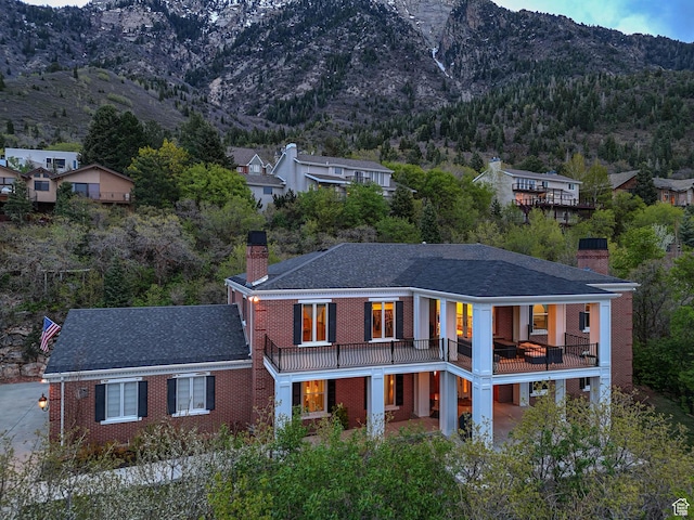 view of front of property with a chimney, a mountain view, and brick siding