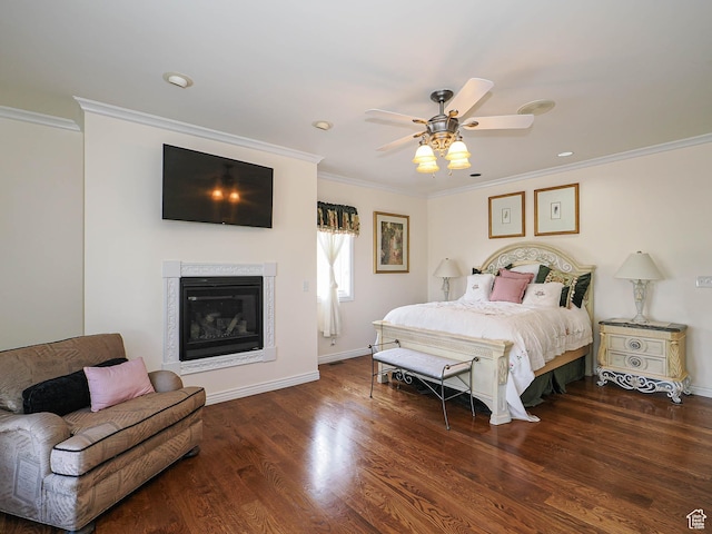 bedroom with a glass covered fireplace, crown molding, a ceiling fan, baseboards, and wood finished floors