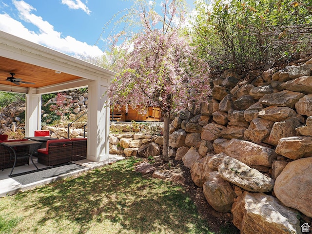 view of yard with outdoor lounge area, ceiling fan, and a patio area