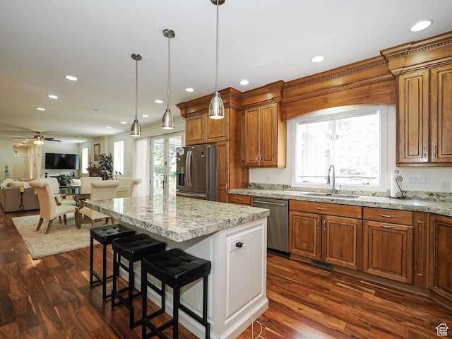 kitchen featuring brown cabinetry, stainless steel appliances, recessed lighting, and a sink