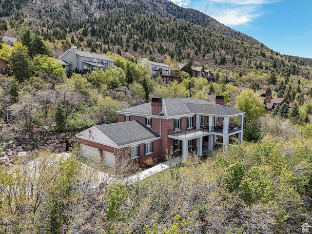 birds eye view of property with a mountain view and a wooded view