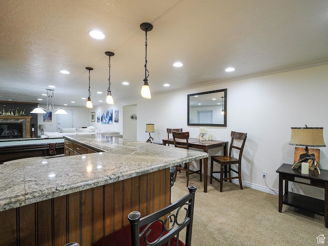 kitchen with baseboards, light stone countertops, ornamental molding, recessed lighting, and light carpet