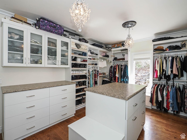 spacious closet featuring an inviting chandelier and dark wood-type flooring