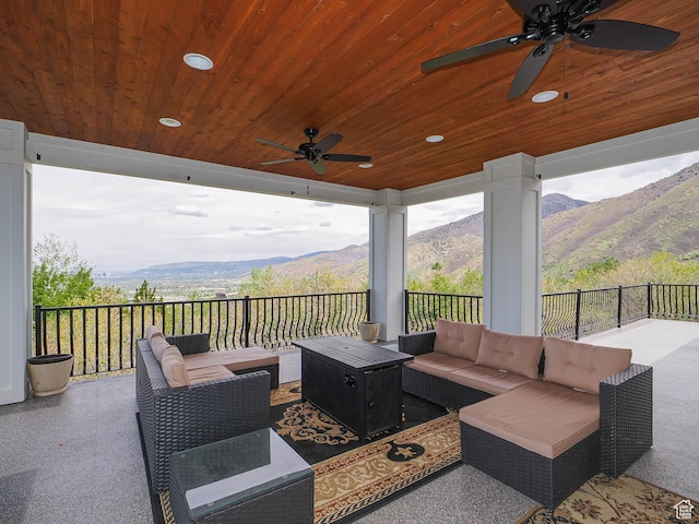 view of patio / terrace with an outdoor living space, a mountain view, and a ceiling fan