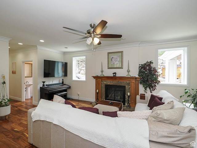 living room with crown molding, ceiling fan, baseboards, recessed lighting, and a premium fireplace