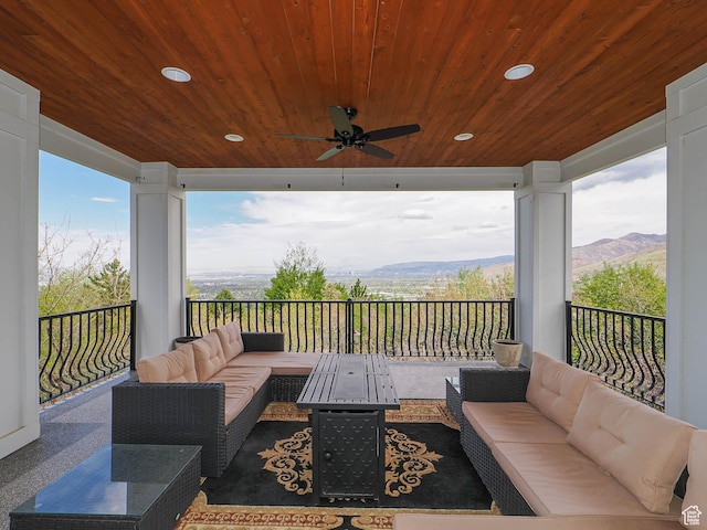 wooden deck featuring ceiling fan, a mountain view, and an outdoor living space