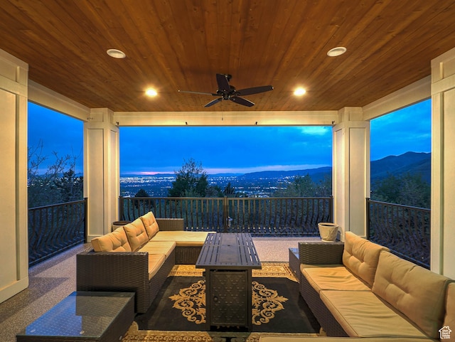 view of patio featuring a ceiling fan, a mountain view, and an outdoor living space