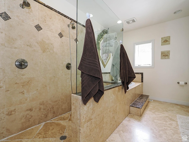 full bathroom with visible vents, baseboards, and tiled shower